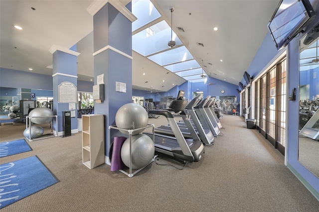 workout area with carpet flooring, a skylight, and high vaulted ceiling