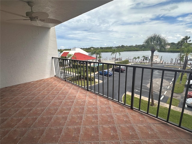 balcony with a water view and ceiling fan