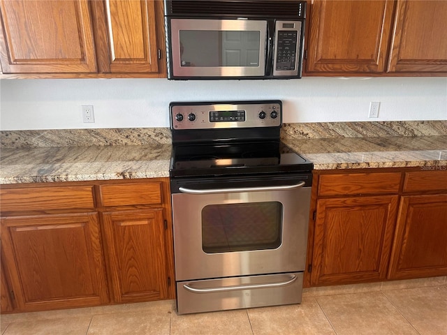 kitchen with appliances with stainless steel finishes and light tile patterned floors