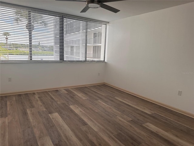 empty room featuring dark wood-type flooring and ceiling fan