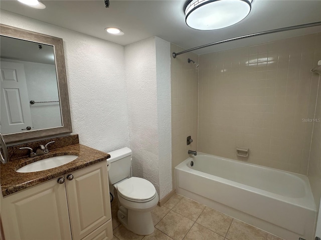 full bathroom featuring tiled shower / bath, vanity, toilet, and tile patterned flooring