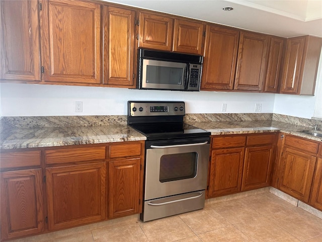 kitchen featuring sink, stone countertops, stainless steel appliances, and light tile patterned floors