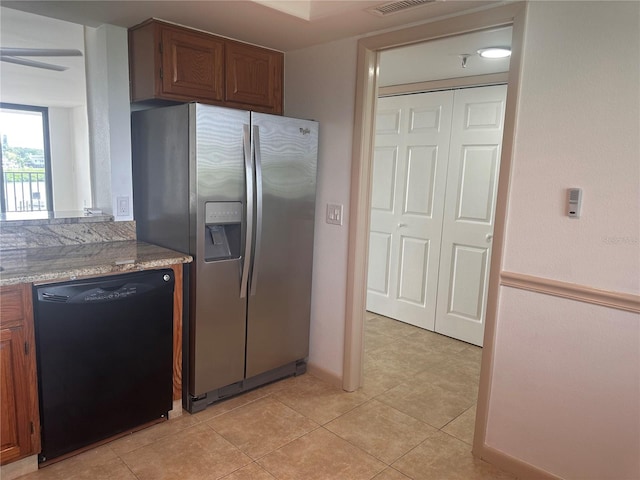 kitchen featuring black dishwasher, light stone countertops, stainless steel refrigerator with ice dispenser, and light tile patterned floors