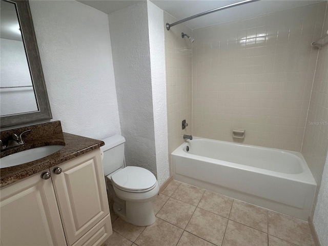 full bathroom with toilet, tiled shower / bath combo, vanity, and tile patterned flooring