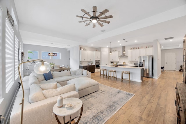 living room featuring ceiling fan and light wood-type flooring