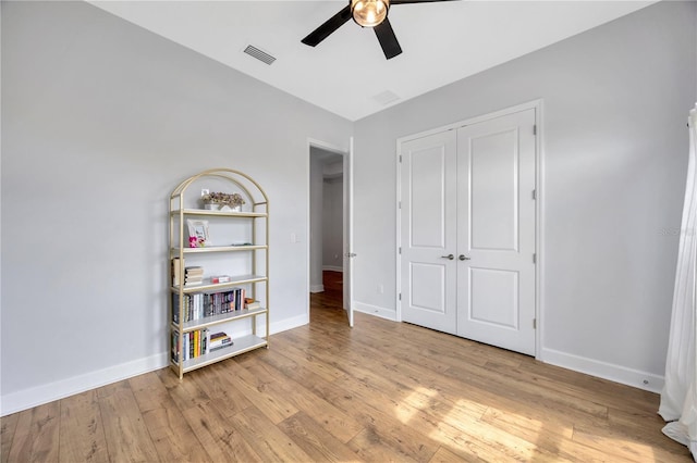 unfurnished bedroom with light hardwood / wood-style floors, a closet, and ceiling fan