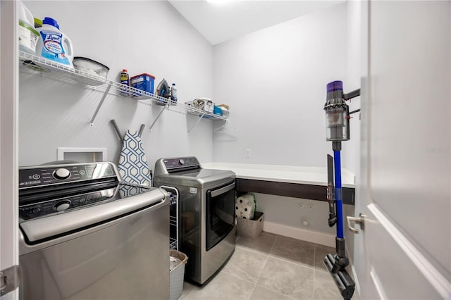 clothes washing area with light tile patterned flooring and washing machine and dryer