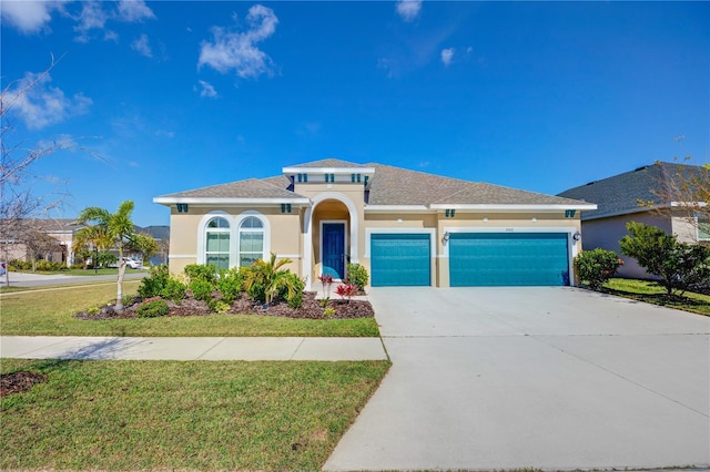 view of front of house with concrete driveway, a front lawn, an attached garage, and stucco siding