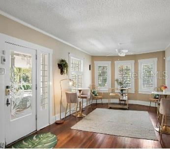 sitting room with a textured ceiling, ornamental molding, and dark hardwood / wood-style floors