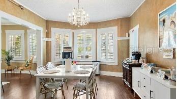 dining area with dark wood-type flooring and an inviting chandelier