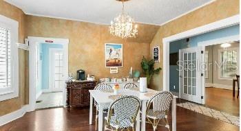 dining space with hardwood / wood-style flooring, an inviting chandelier, and plenty of natural light