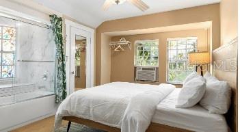 bedroom featuring cooling unit, multiple windows, and ceiling fan