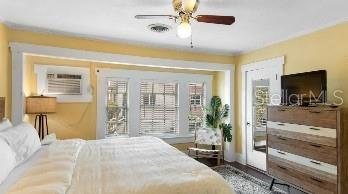 bedroom with ceiling fan and a wall mounted AC