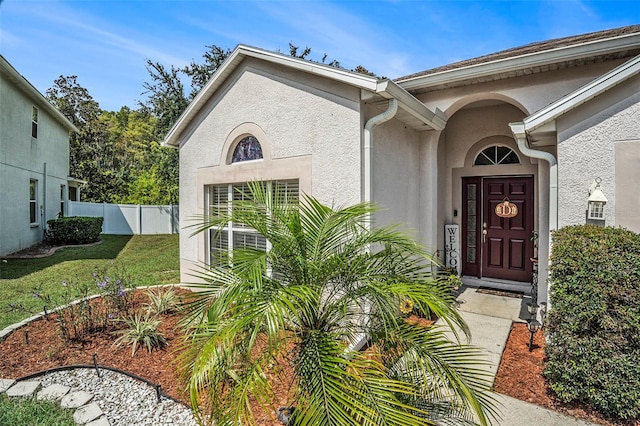 view of exterior entry with a yard