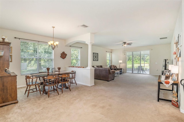 dining area featuring ornate columns, light carpet, and plenty of natural light