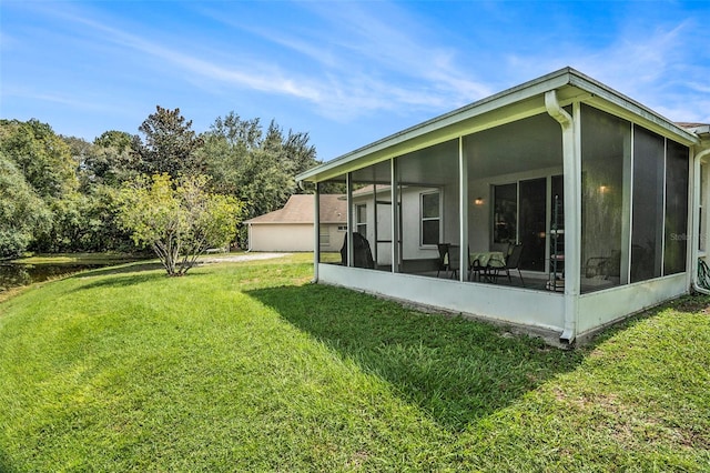 back of house with a lawn and a sunroom