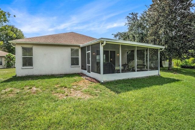 rear view of house with a sunroom and a lawn