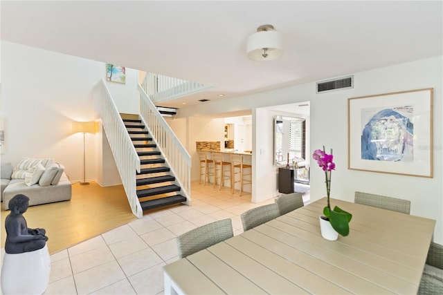 dining space featuring stairs, visible vents, and tile patterned floors