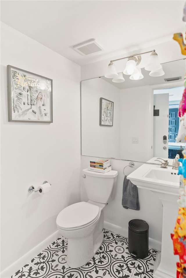 bathroom with toilet, baseboards, visible vents, and tile patterned flooring