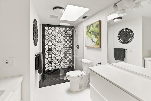 bathroom with a skylight, tile patterned floors, tiled shower, toilet, and vanity