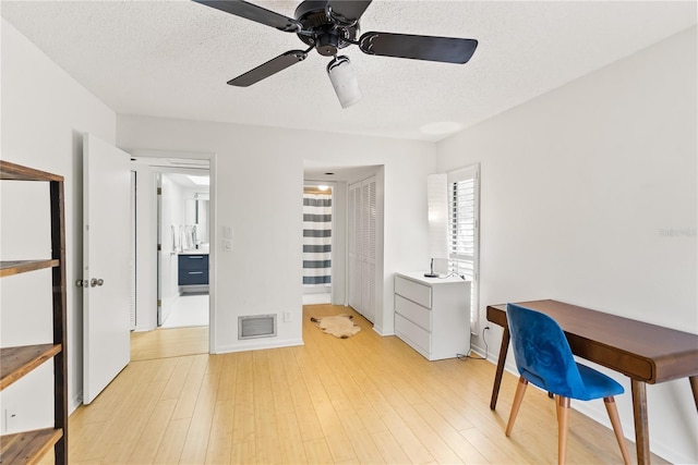 office area featuring a textured ceiling, light hardwood / wood-style flooring, and ceiling fan