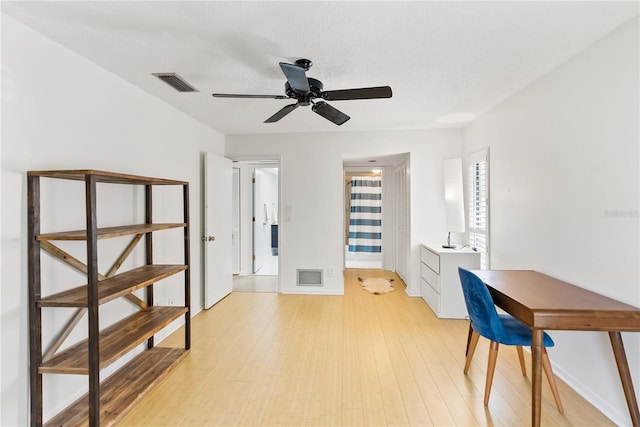 office space featuring ceiling fan, light hardwood / wood-style flooring, and a textured ceiling