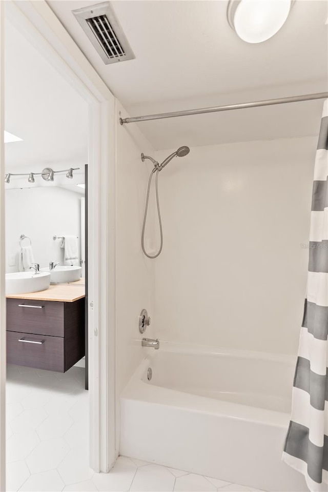 bathroom with tile patterned floors, shower / bath combo with shower curtain, and vanity