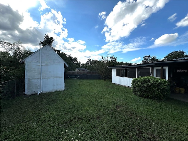 view of yard with a shed and a sunroom