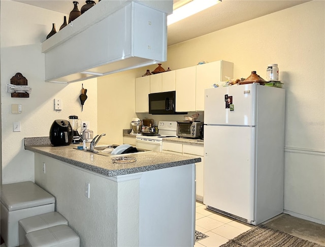 kitchen with kitchen peninsula, white cabinets, sink, and white appliances