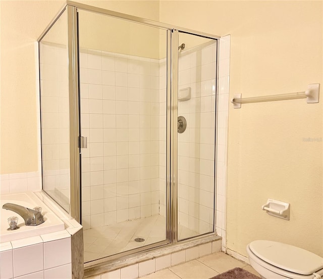 bathroom featuring tile patterned flooring, toilet, and separate shower and tub