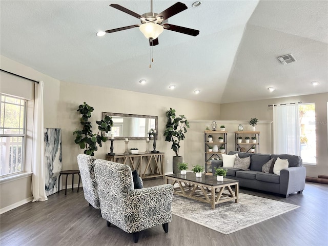 living room with dark hardwood / wood-style flooring, a textured ceiling, ceiling fan, and vaulted ceiling