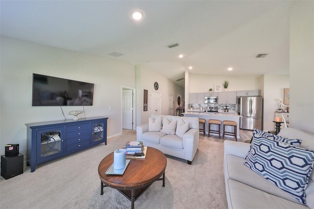 carpeted living room featuring lofted ceiling