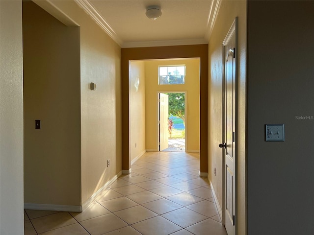 corridor with light tile patterned flooring and ornamental molding