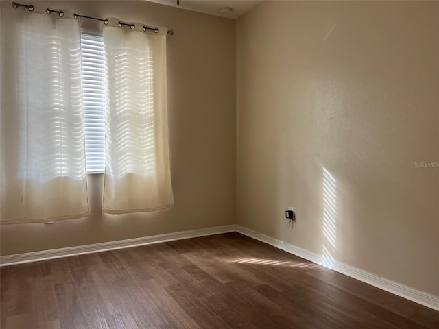 unfurnished room with dark hardwood / wood-style flooring