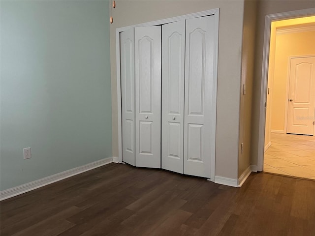 unfurnished bedroom featuring a closet and dark hardwood / wood-style floors