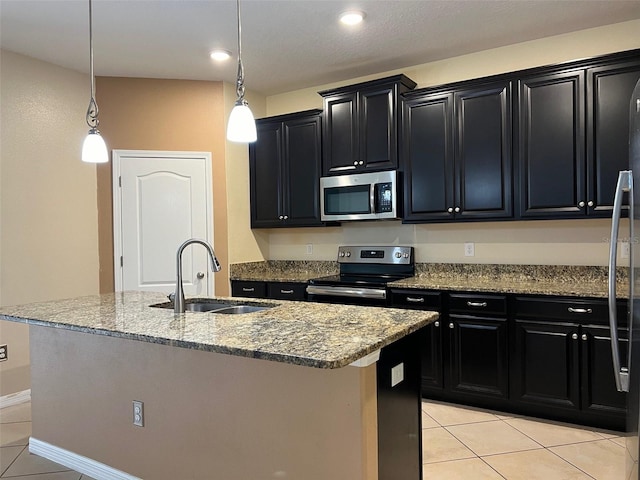 kitchen with stainless steel appliances, a kitchen island with sink, sink, pendant lighting, and light tile patterned flooring