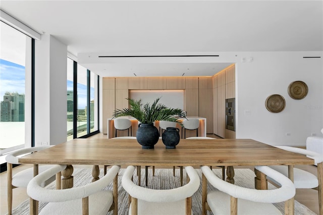 dining space featuring expansive windows and a healthy amount of sunlight