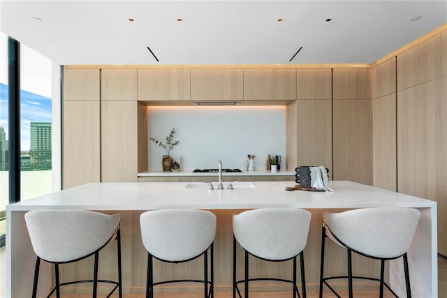 1000 Water St Unit 1402, Tampa, FL 33602 - kitchen with modern cabinets, light brown cabinetry, light countertops, and an island with sink