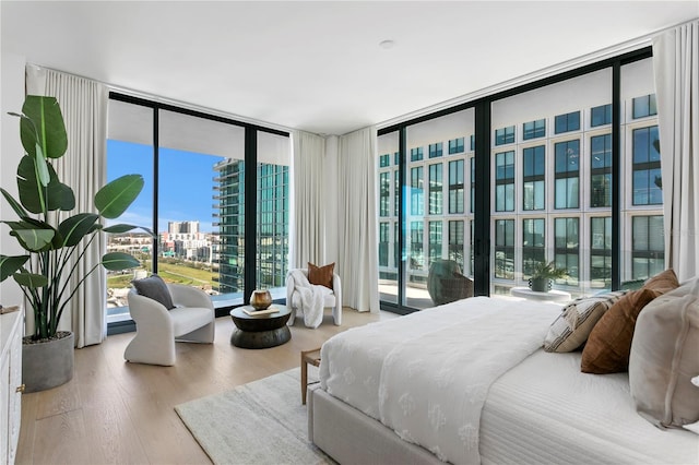 bedroom with wood-type flooring and floor to ceiling windows