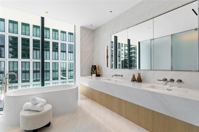 bathroom featuring vanity, a washtub, and tile walls