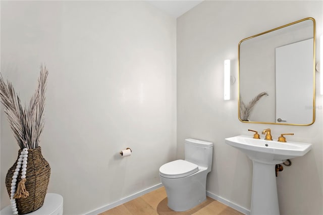 bathroom featuring hardwood / wood-style flooring and toilet