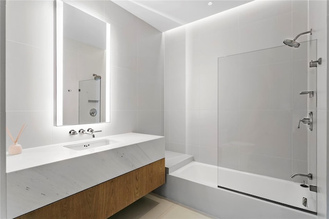 bathroom featuring tile walls, vanity, tiled shower / bath, and tile patterned flooring