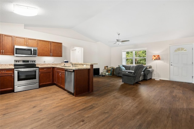 kitchen with lofted ceiling, appliances with stainless steel finishes, kitchen peninsula, and dark hardwood / wood-style floors