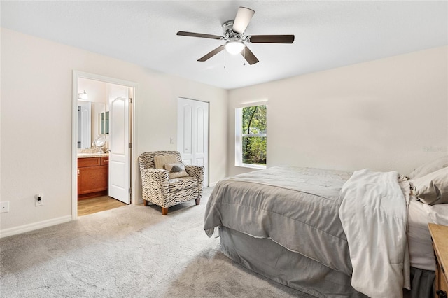 bedroom featuring ensuite bath, light carpet, a closet, and ceiling fan