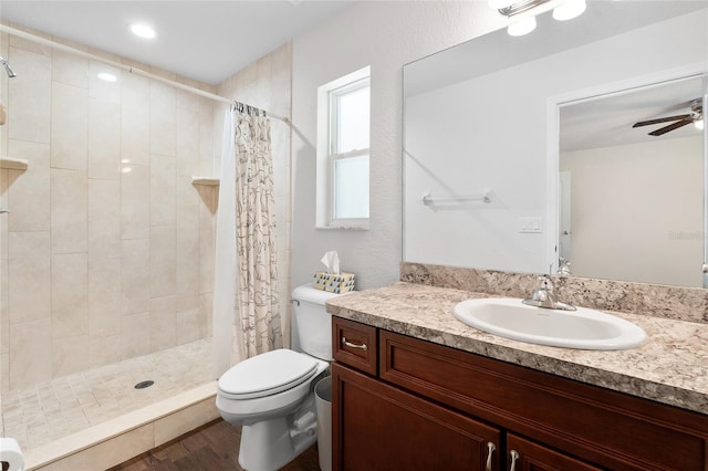 bathroom featuring toilet, ceiling fan, a shower with curtain, vanity, and hardwood / wood-style flooring