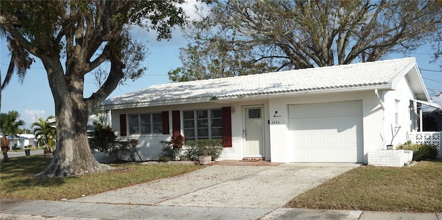 single story home with a garage and a front lawn