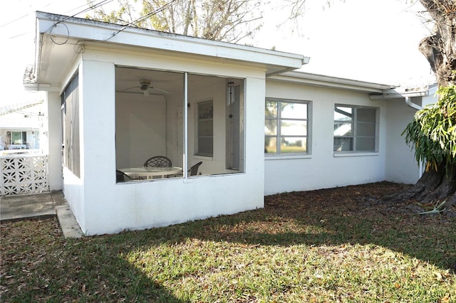 view of property exterior featuring ceiling fan and a sunroom