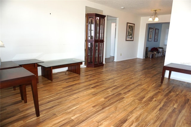 interior space with hardwood / wood-style flooring, a chandelier, and a textured ceiling