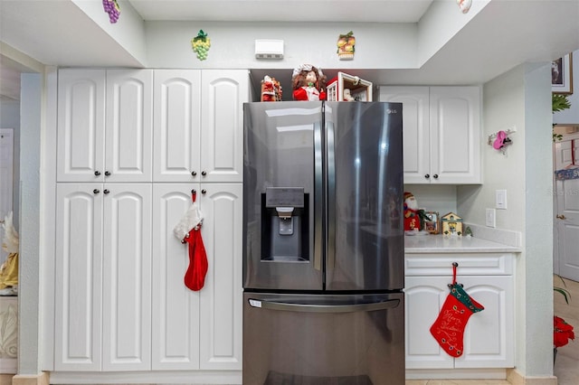 kitchen featuring white cabinets and stainless steel fridge