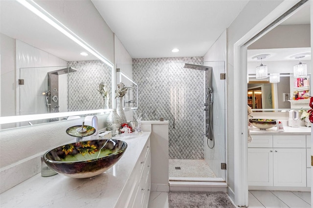 bathroom featuring tile patterned flooring, vanity, and a shower with door